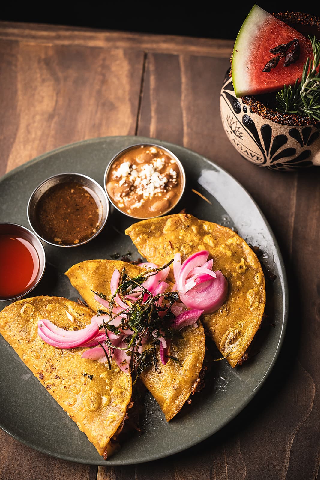 Golden birria tacos plated with consommé