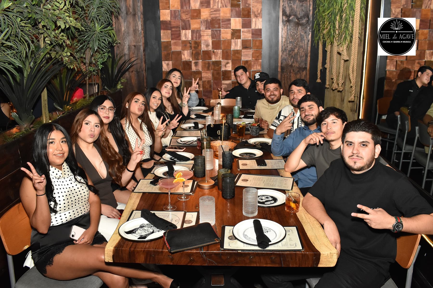A large group of guests celebrating around a Miel de Agave table